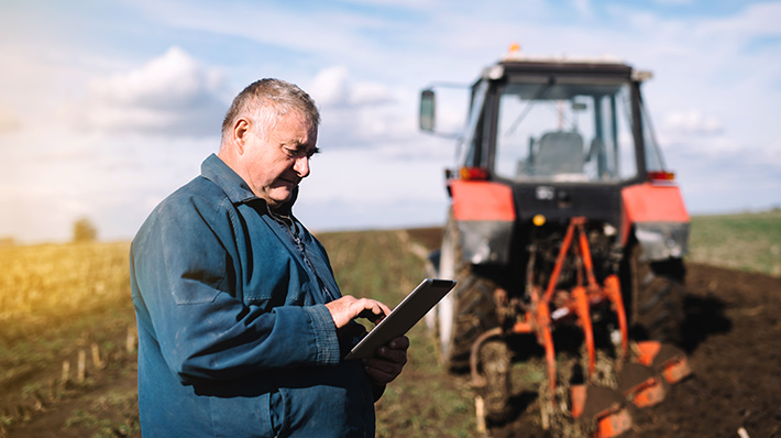 Farmer in field using tablet with rural internet options